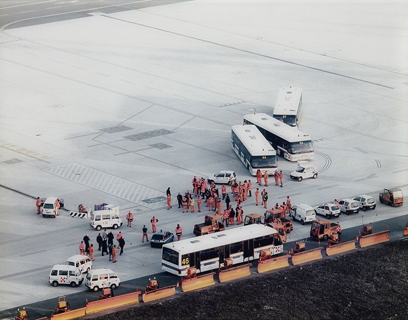 Men in orange, Malpensa